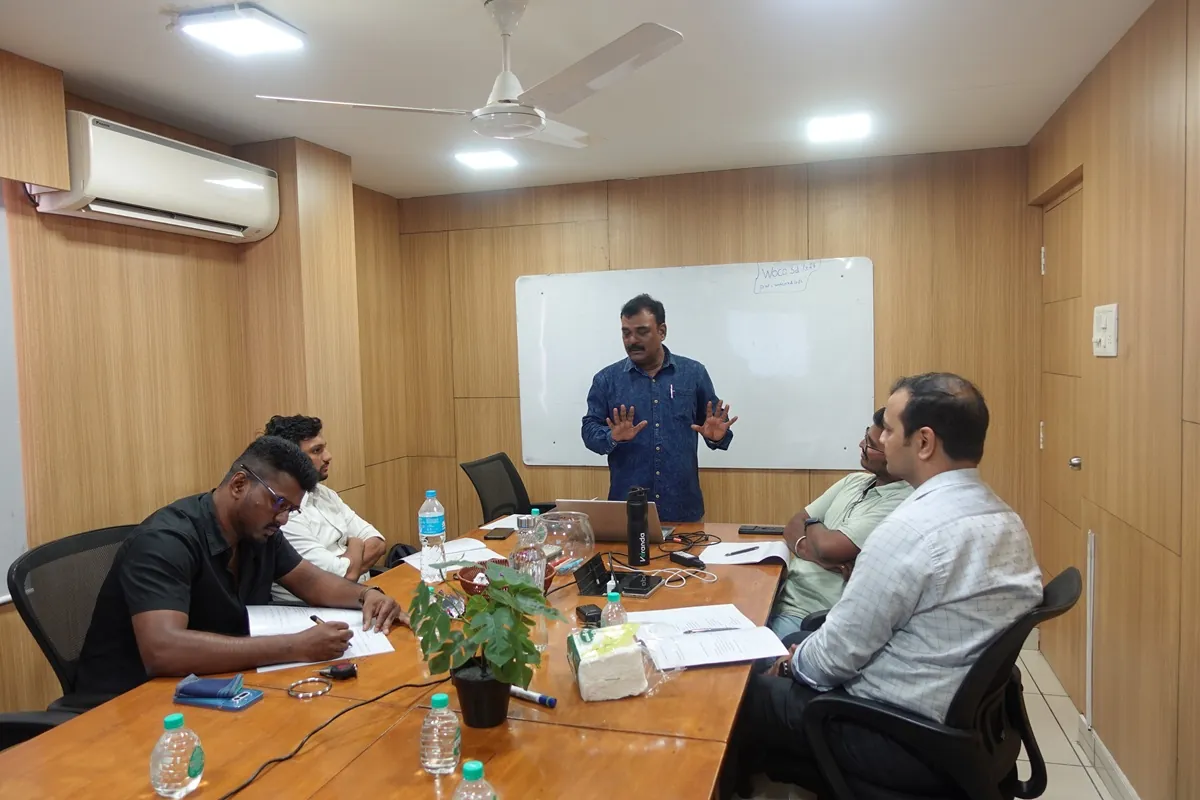 Mohan Kumar facilitating a money conversation session around a meeting table